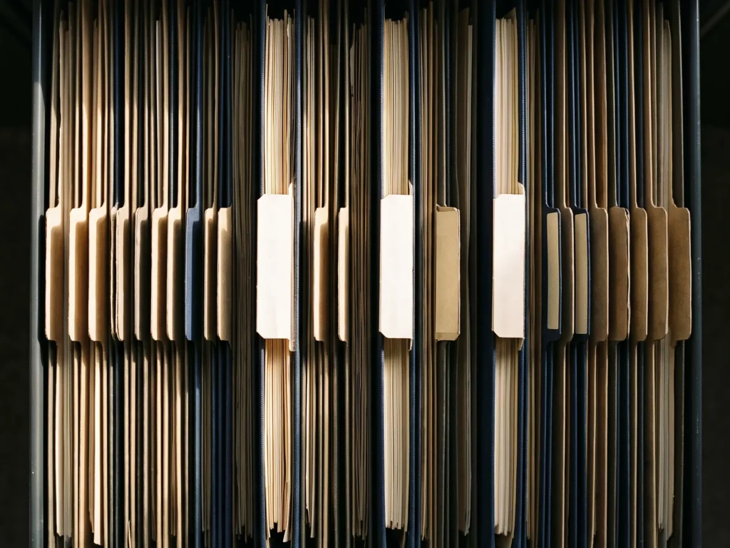 Cenital de un cajón de archivo con carpetas colgantes en hilera y cuatro claramente levantadas por encima de las demás.
